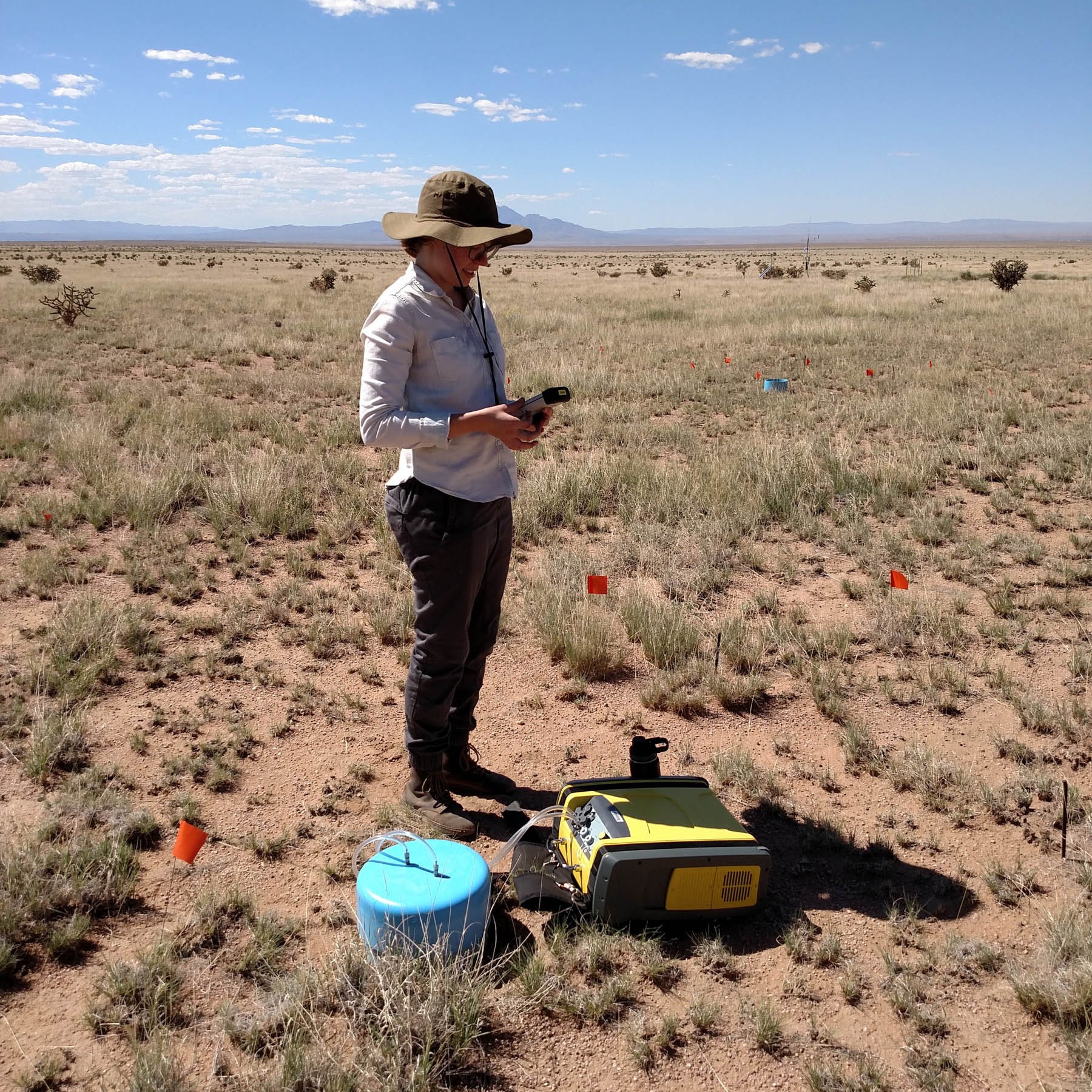 A researcher takes soil respiration readings using a portable flux machine.